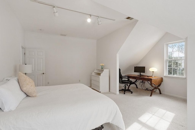 bedroom with light colored carpet, rail lighting, and vaulted ceiling