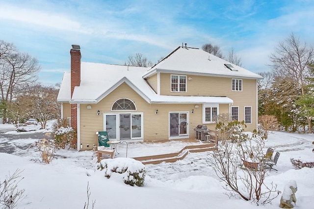 view of snow covered rear of property