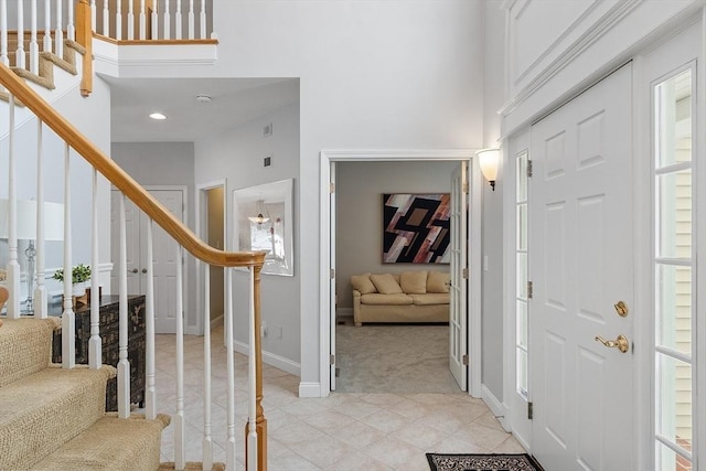 carpeted foyer featuring a high ceiling