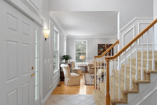 foyer entrance featuring ornamental molding and light tile patterned floors