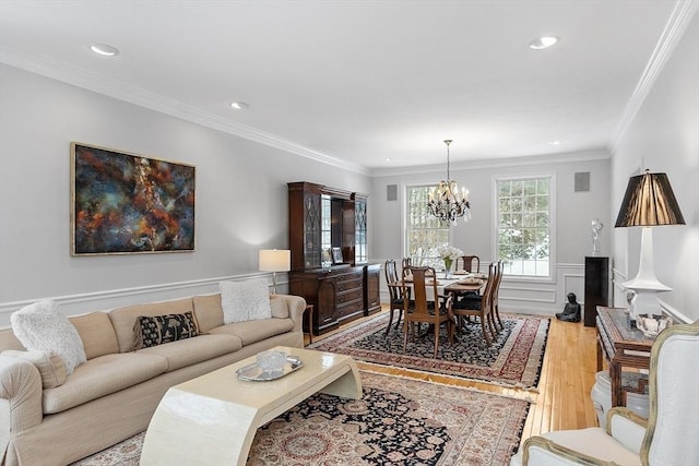 living room featuring crown molding, hardwood / wood-style floors, and an inviting chandelier