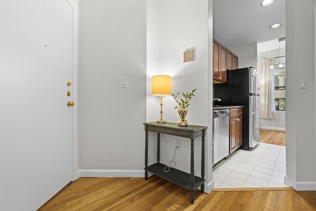 foyer entrance featuring light wood-type flooring, baseboards, and recessed lighting