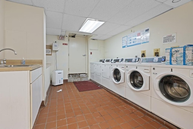 clothes washing area with cabinet space, washing machine and dryer, and tile patterned floors