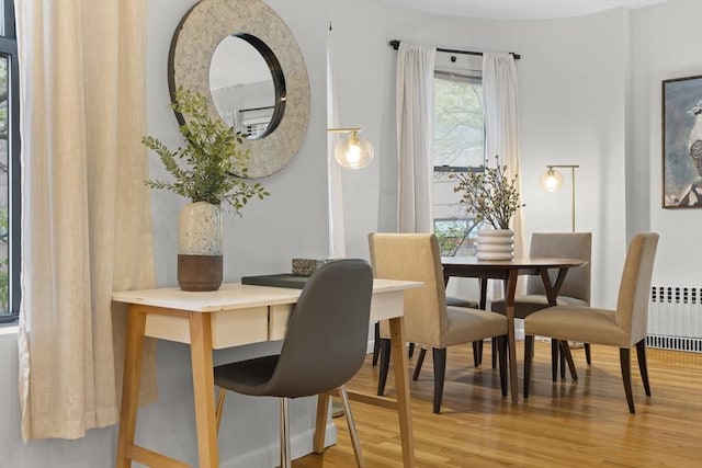 dining space featuring light wood-style floors and radiator