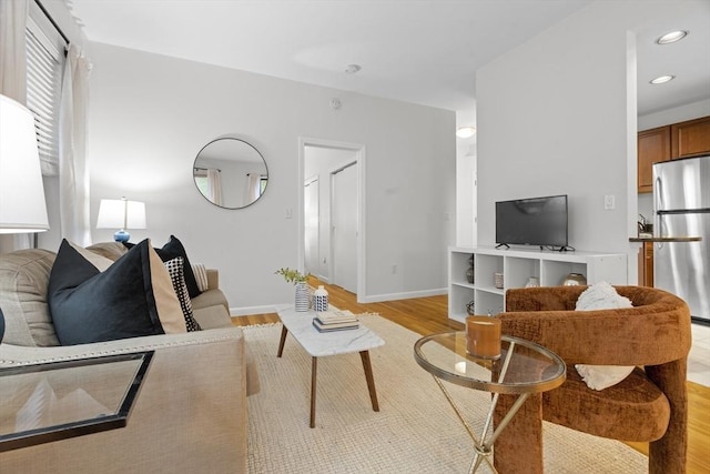 living room with light wood-type flooring, baseboards, and recessed lighting