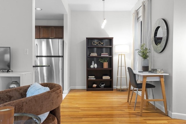 sitting room featuring light wood-style floors, baseboards, and recessed lighting