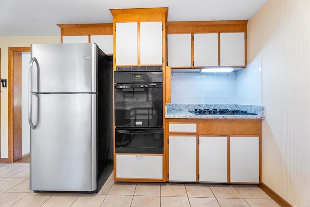 76 N Main St, Bellingham, MA 02019 - kitchen with freestanding refrigerator, black oven, a warming drawer, and light tile patterned floors
