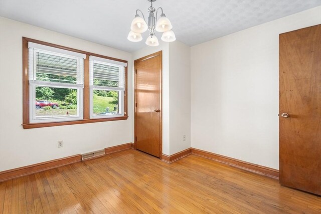 76 N Main St, Bellingham, MA 02019 - unfurnished room with a chandelier, baseboards, and light wood-type flooring