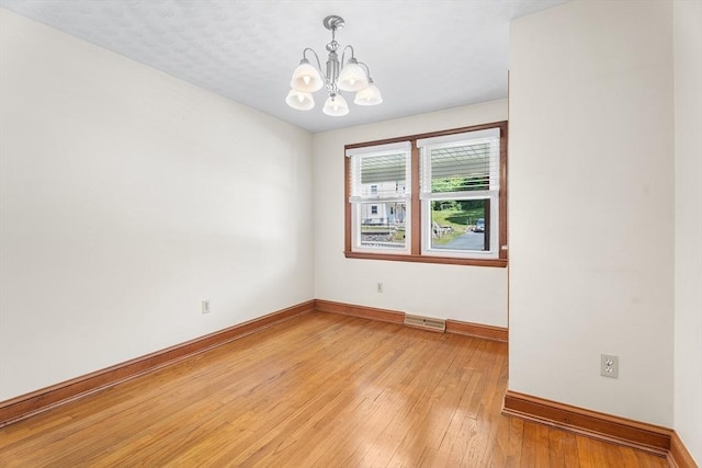 76 N Main St, Bellingham, MA 02019 - unfurnished room featuring a chandelier, baseboards, and light wood-style flooring