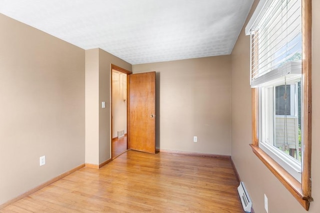76 N Main St, Bellingham, MA 02019 - spare room with light wood finished floors, baseboard heating, and baseboards