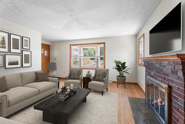 76 N Main St, Bellingham, MA 02019 - living area featuring wood finished floors, a fireplace, baseboards, and a baseboard heating unit
