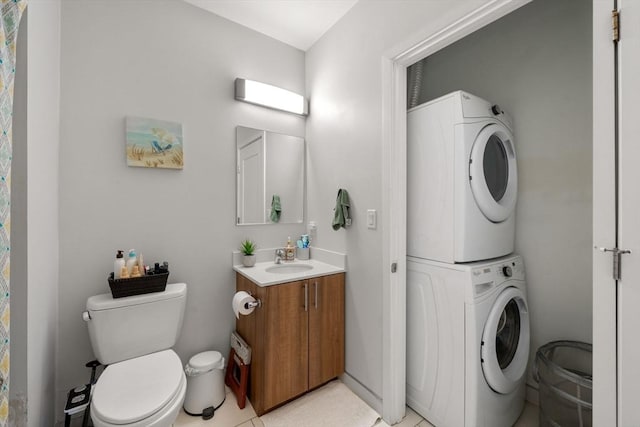 bathroom with toilet, vanity, and stacked washer / drying machine