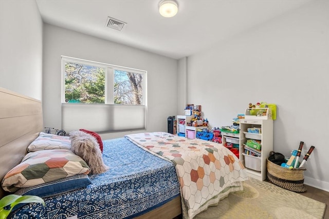 bedroom with visible vents and wood finished floors