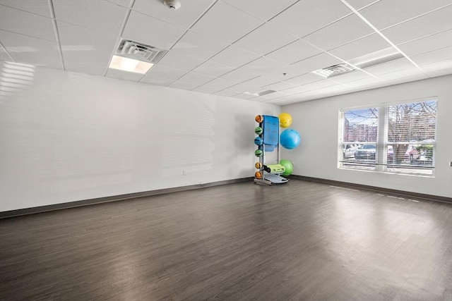 interior space with visible vents, baseboards, a paneled ceiling, and wood finished floors