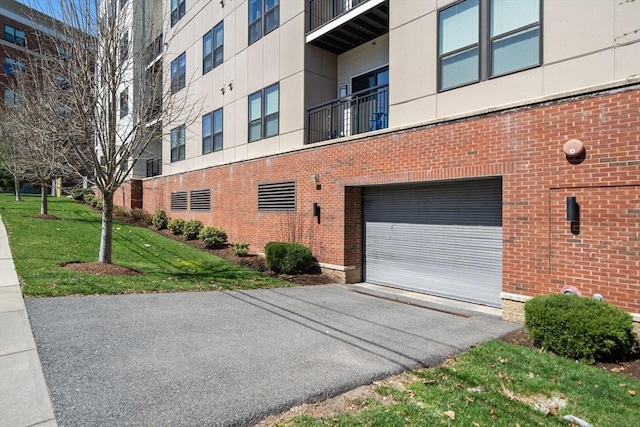 view of building exterior featuring aphalt driveway and an attached garage