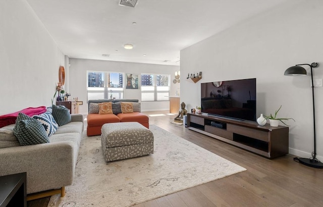 living area with baseboards and wood finished floors
