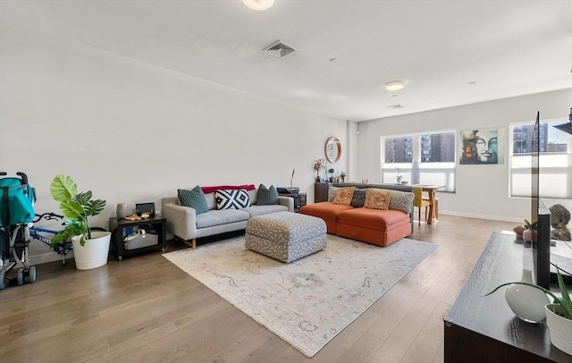 living area featuring visible vents, baseboards, and light wood-style flooring