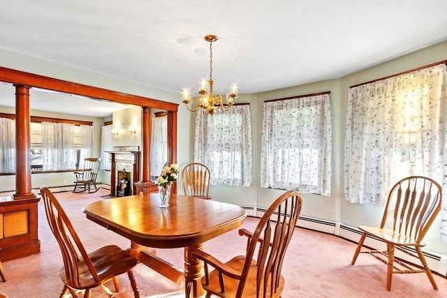 dining area featuring light carpet, decorative columns, and a notable chandelier