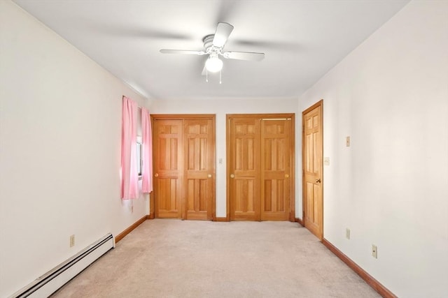 unfurnished bedroom featuring multiple closets, ceiling fan, light colored carpet, and a baseboard radiator