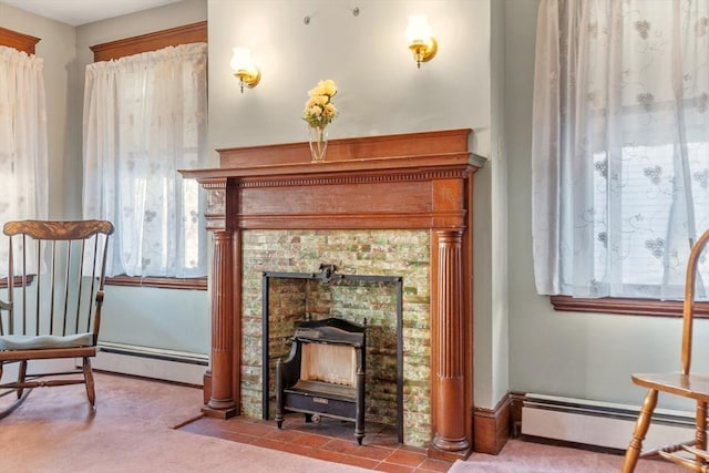 living area featuring a tile fireplace, a baseboard radiator, and carpet floors