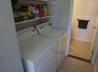 laundry room with washing machine and dryer and light tile patterned floors