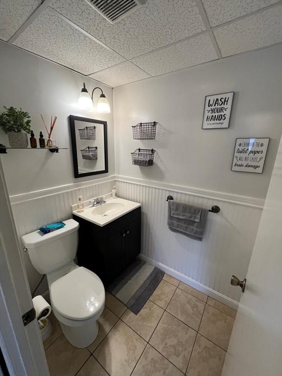 bathroom featuring a paneled ceiling, vanity, and tile patterned floors