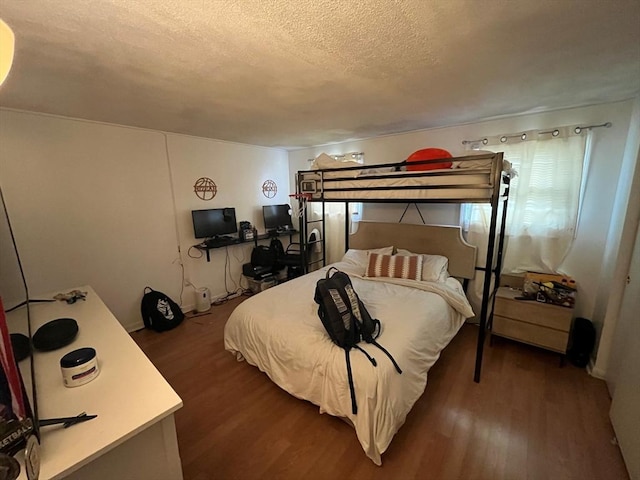 bedroom featuring wood-type flooring and a textured ceiling