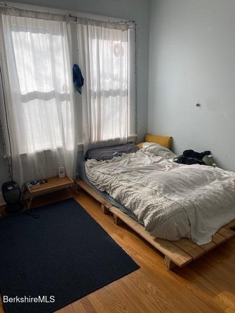 bedroom with multiple windows and hardwood / wood-style floors