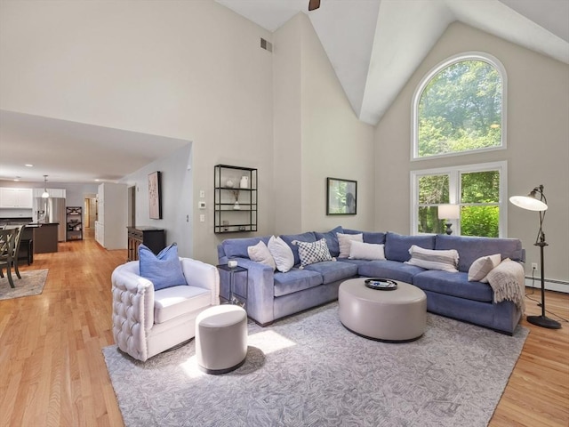 200 Newtown Rd, Acton, MA 01720 - living area with high vaulted ceiling, light wood-type flooring, and baseboard heating
