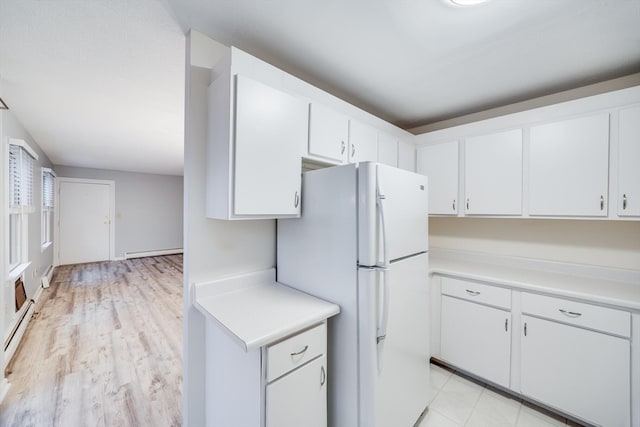 kitchen with white refrigerator, light hardwood / wood-style floors, white cabinetry, and a baseboard heating unit