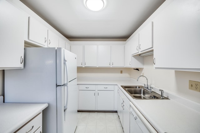 kitchen featuring white appliances, white cabinetry, sink, and light tile patterned floors