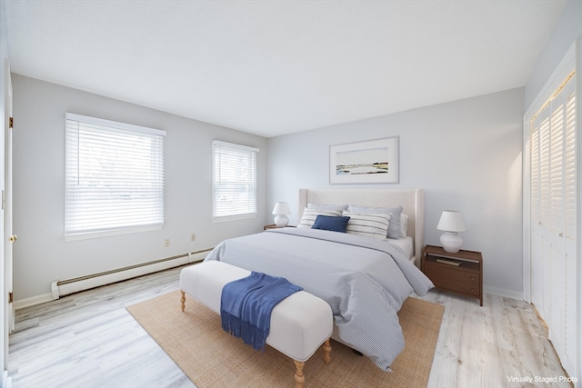 bedroom featuring light wood-type flooring and a baseboard radiator