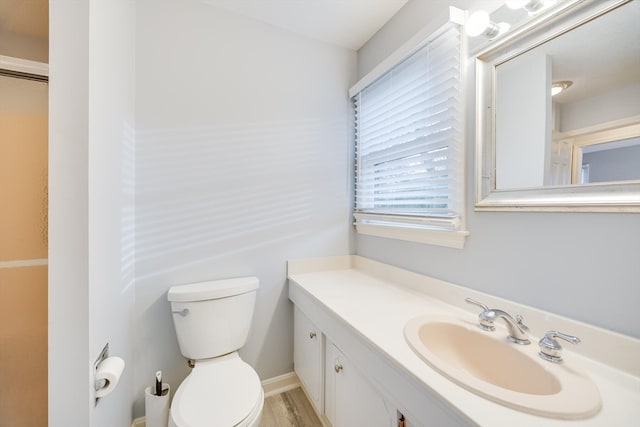 bathroom featuring vanity, hardwood / wood-style flooring, and toilet