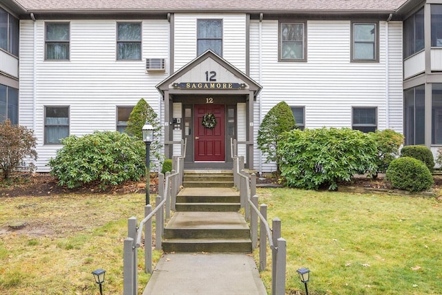 view of exterior entry featuring a yard