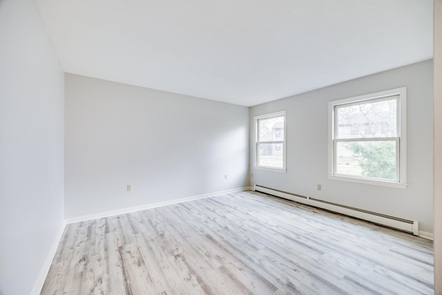 unfurnished room featuring light hardwood / wood-style floors and a baseboard heating unit