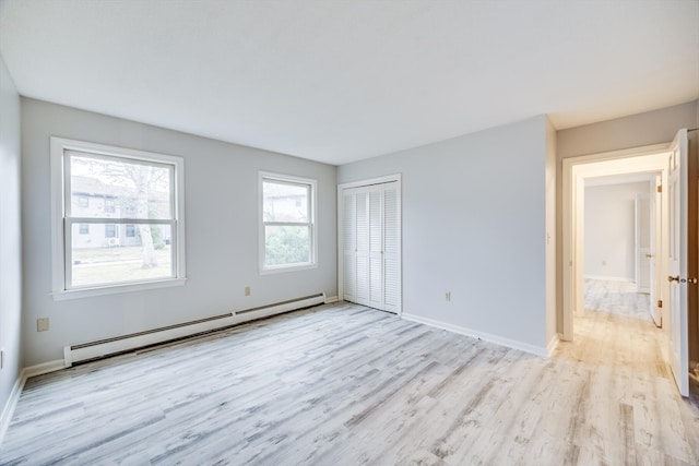 spare room featuring light hardwood / wood-style flooring and a baseboard heating unit