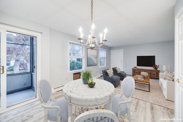 dining room featuring a chandelier, light hardwood / wood-style floors, and a baseboard heating unit