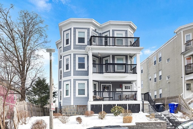 view of front of property featuring a balcony and fence