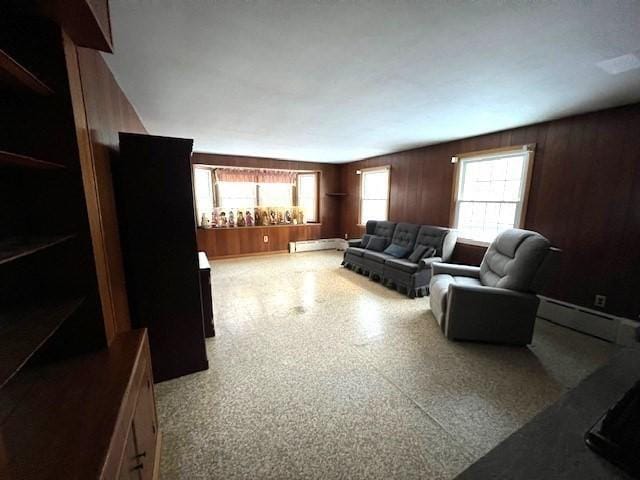 living room featuring wood walls and a baseboard heating unit