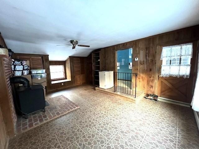 unfurnished living room with wooden walls and ceiling fan