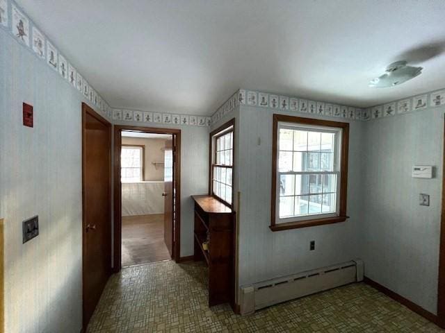 interior space with a baseboard radiator and a healthy amount of sunlight