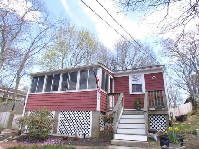 view of front of property featuring stairs and a sunroom