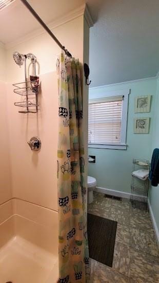 bathroom featuring crown molding, toilet, a shower with shower curtain, and baseboards