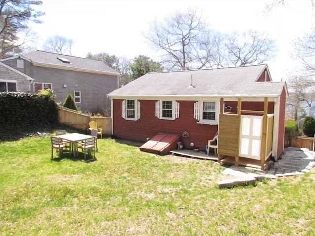 back of property featuring a yard and fence