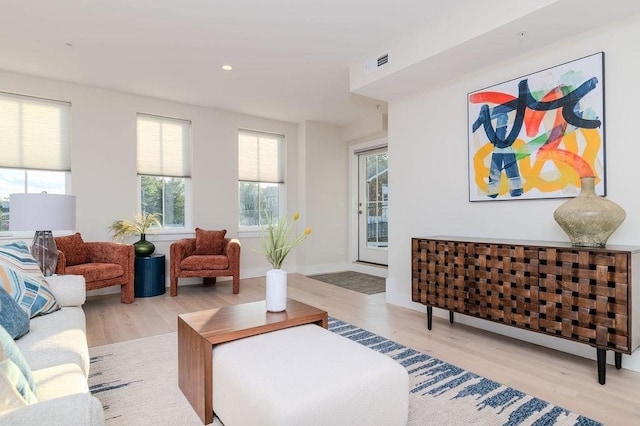 living room with baseboards, wood finished floors, visible vents, and recessed lighting