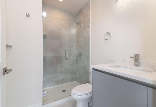 bathroom with toilet, a shower stall, and vanity