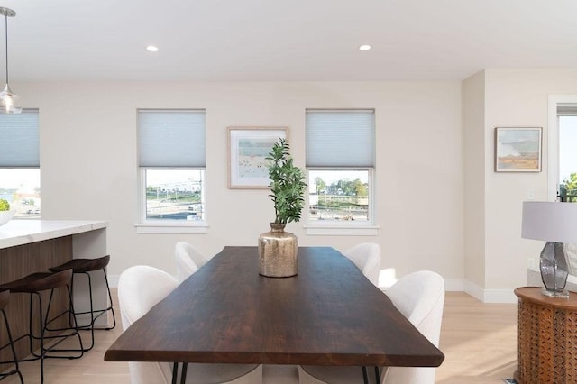 dining space featuring baseboards, light wood finished floors, and recessed lighting