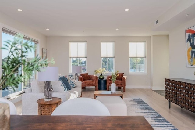 living room featuring recessed lighting, baseboards, visible vents, and light wood finished floors