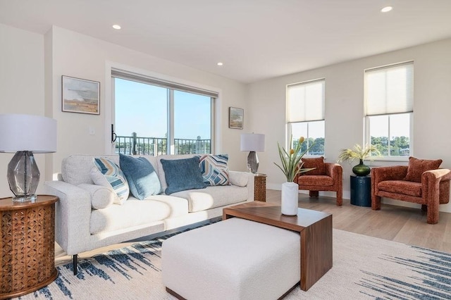 living area with plenty of natural light, light wood-style flooring, and recessed lighting