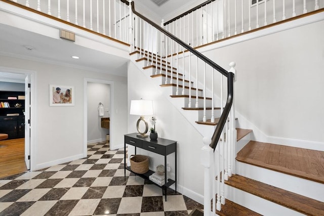 stairway featuring crown molding, recessed lighting, baseboards, and a high ceiling